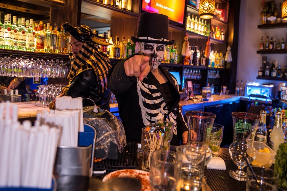 Bartender caracterizado de esqueleto animando la barra en una fiesta temática de Halloween